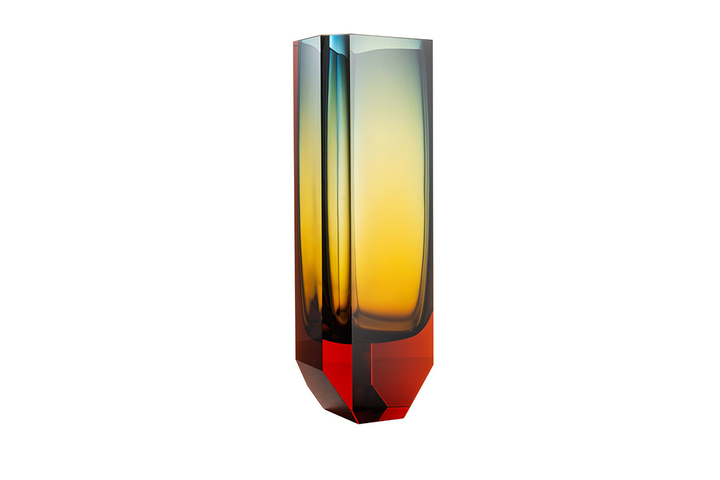 The Magnus vase is handmade using the technique of injected underlaying. This injection method gradually dissipates as the honey-brown topaz combined with blue creates yet a third colour: yellow-green. This effect is born as the colours and their changing intensities mutually overlap, making every vase completely unique. Monumental brutalism and delicate glasswork flow together in surprising harmony.